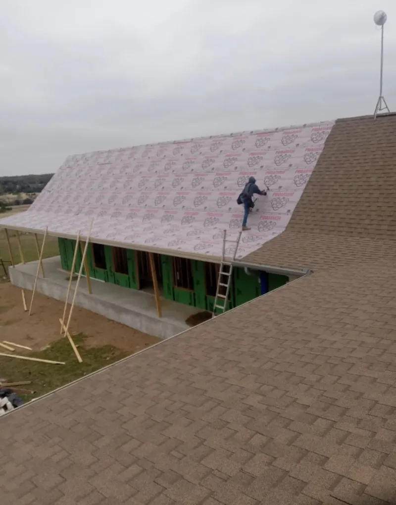 Worker preparing underlayment for a metal roof installation in North Codorus